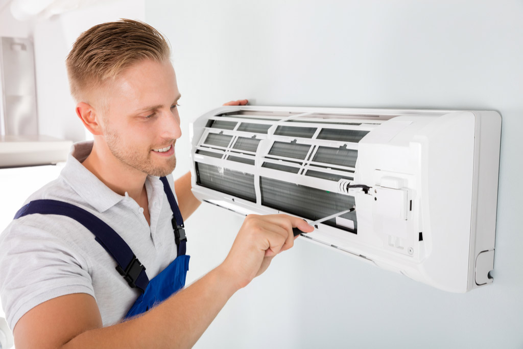 HVAC technician cleaning and repairing a ductless mini split AC in Aurora, CO