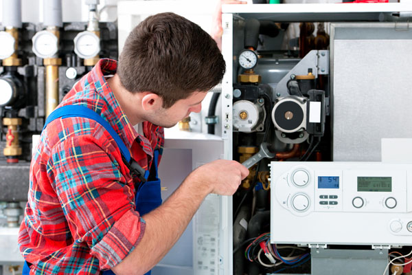 HVAC technician inspecting an indoor heating system in Aurora, CO