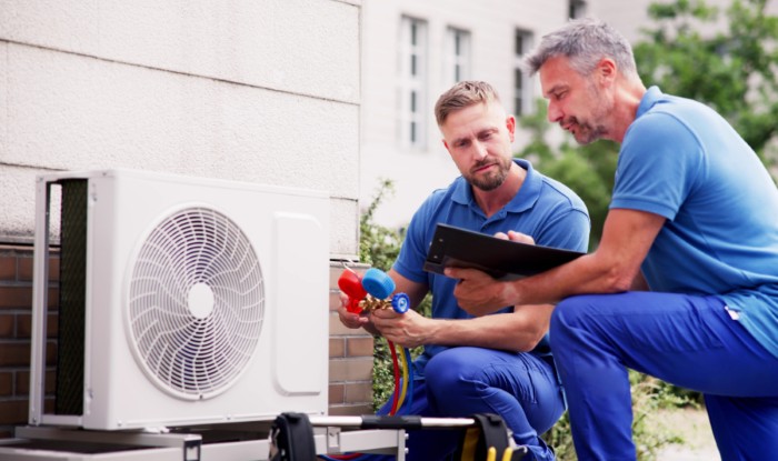 HVAC technicians installing an outdoor air conditioning unit in Aurora