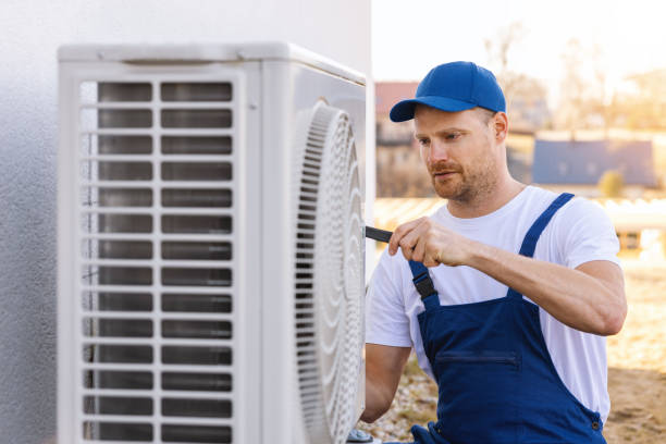 HVAC technician servicing an outdoor air conditioning unit in Aurora